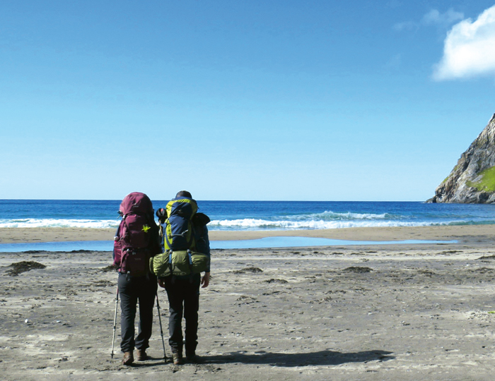 Zwei Wanderer an dem Sandstrand von Kvalvika 