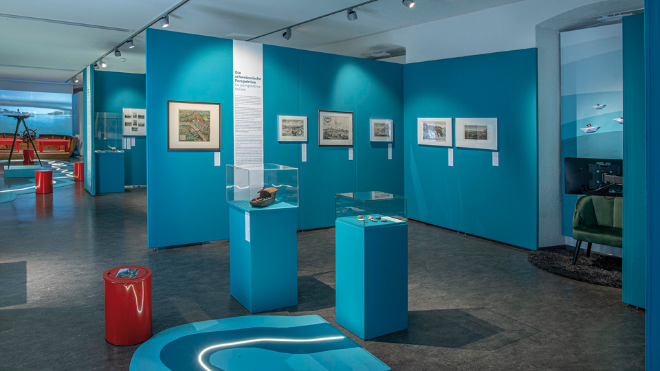 Ausstellungsraum mit blauen Wänden und Vitrinen
