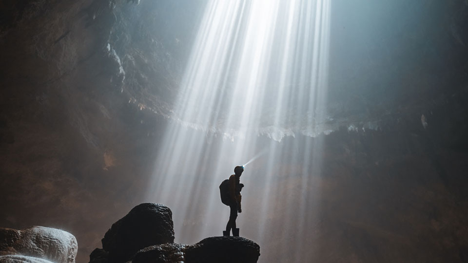 Fotograf Long-Nong stehend auf einem Stein in einer Höhle in Java