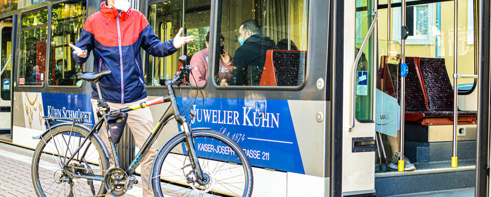 Till Neumann mit seinem Fahrrad verwirrt vor der Straßenbahn