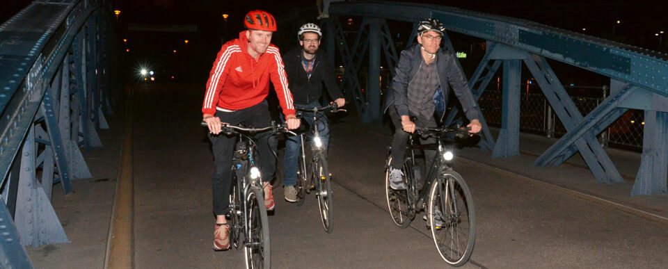 Till Neumann (v.l.), Pascal Lienhard und Philip Thomas auf Fahrrädern