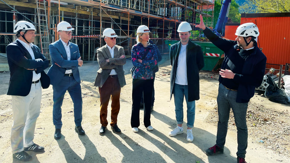 Ein Foto mit 6 Menschen die vor einer Baustelle stehen.
