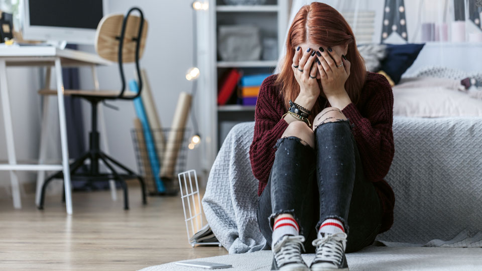 Mädchen sitz vor Bett