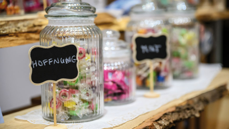 Messestand mit Süßigkeitengläser und kleinem Schild mit der Aufschrift "Hoffnung"