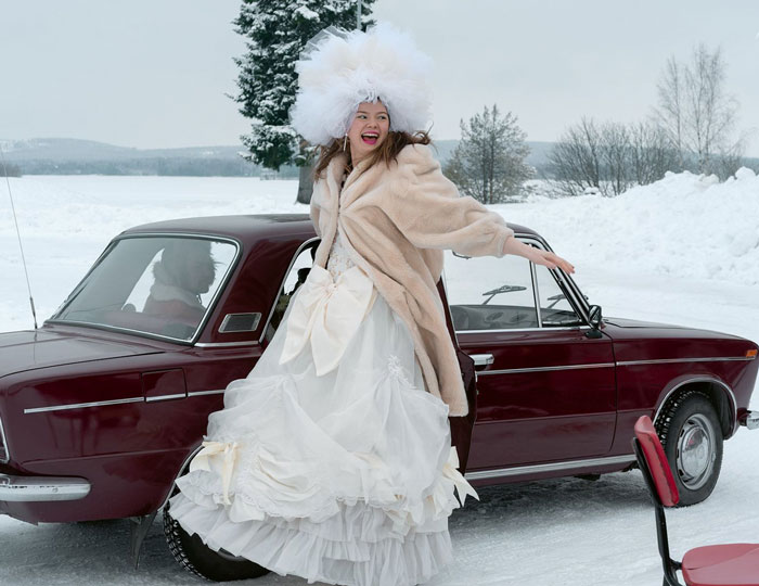 Frau vor Auto im Schnee