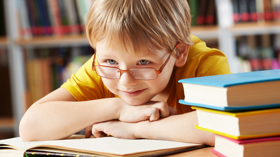 Schüler neben Bücherstapel