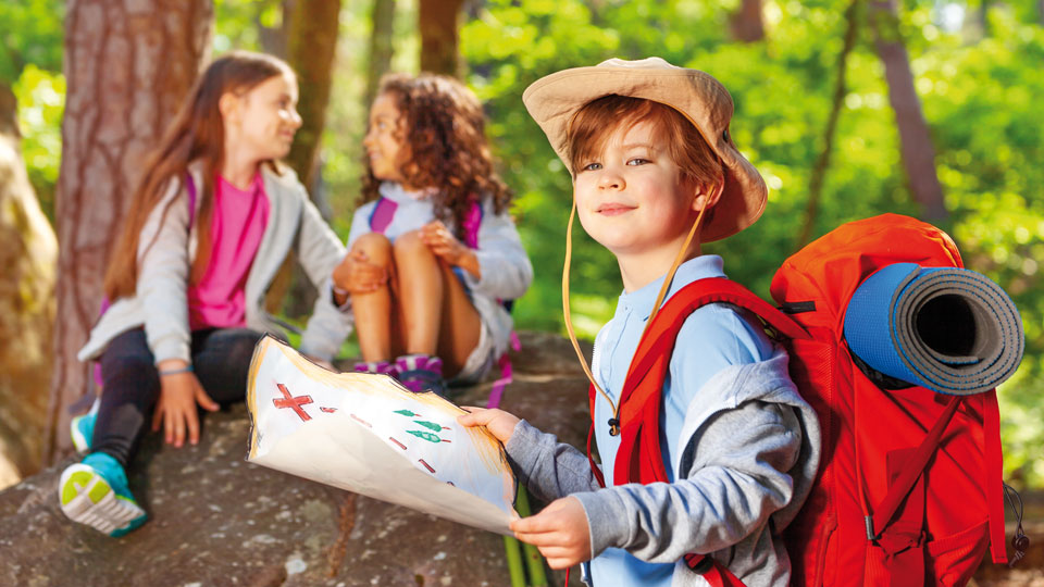 Junge Kindergruppe im Wald bei einer Schnitzeljagd