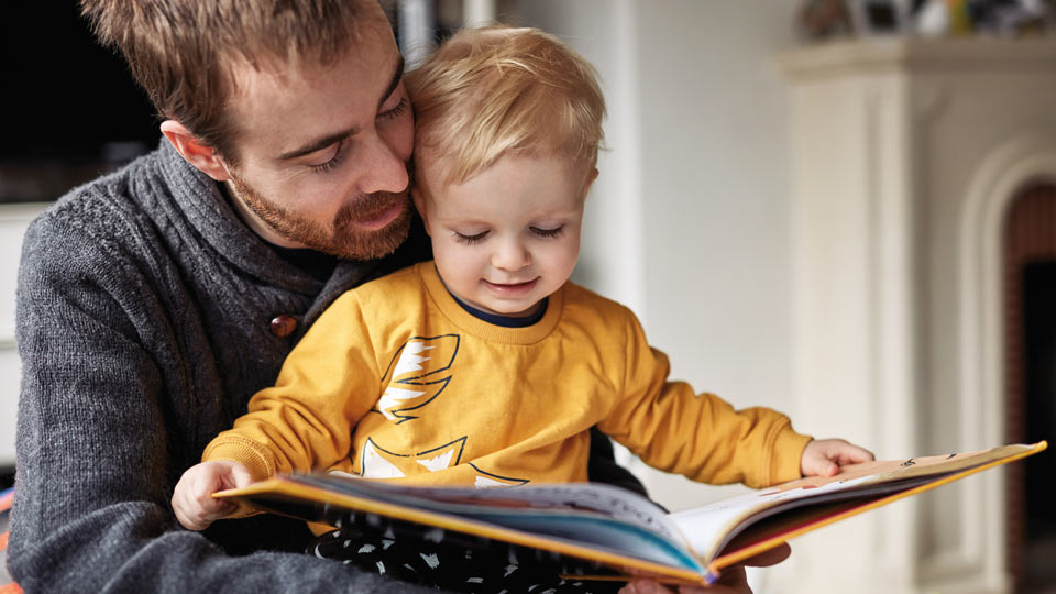 Ein Vater liest gemeinsam mit seinem kleinen Sohn ein Buch