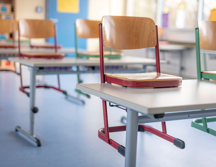 Ein Klassenzimmer mit hochgestellten Stühlen.