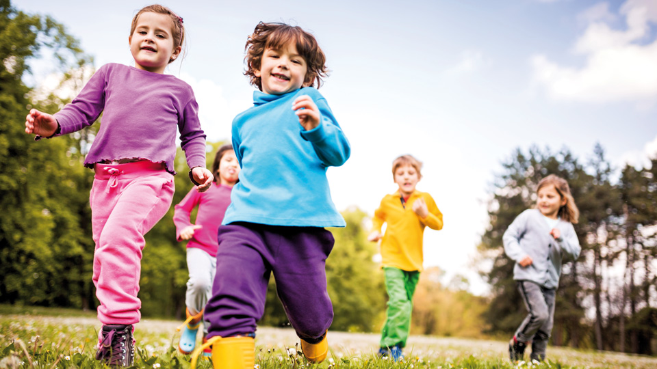 Kindergruppe rennt über eine Wiese