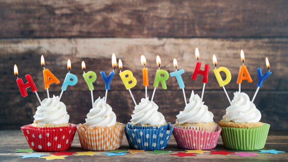 Muffins mit Kerzen die "Happy Birthday" buchstabieren