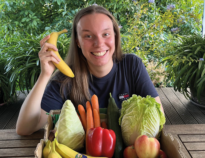 Jana Hamberger mit einer Kiste Obst und Gemüse