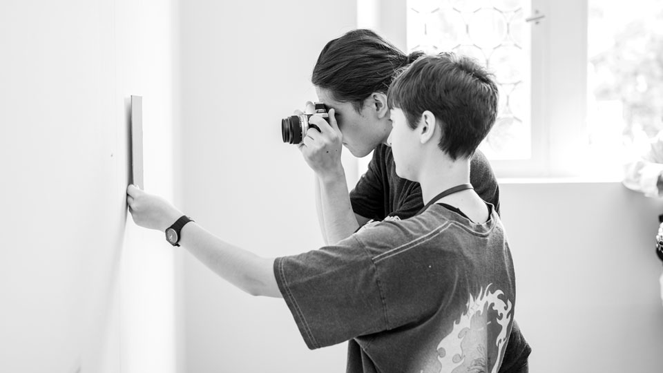 Akademie für Kommunikation: zwei Schüler, die was fotografieren