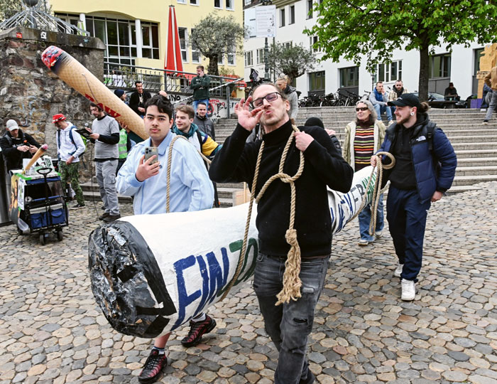 Mehrere Personen tragen einen überdimensionierten Joint