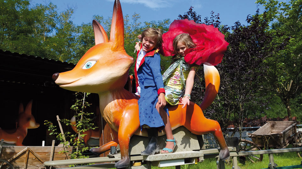 Parc du Petit Prince: zwei Kinder auf einem großen Fuchs