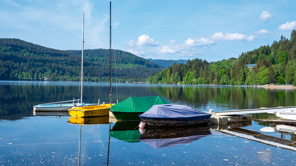 Titisee mit einem Steg, an dem Boote anliegen